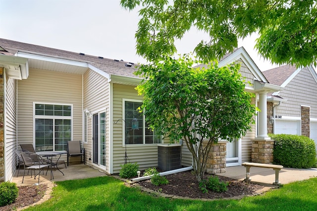 280 S 79th St Unit 1302, West Des Moines, IA 50266 - view of home's exterior with cooling unit, a shingled roof, and a patio