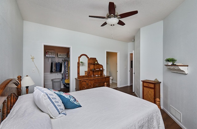 280 S 79th St Unit 1302, West Des Moines, IA 50266 - bedroom featuring dark wood-style floors, baseboards, a walk in closet, a ceiling fan, and a closet