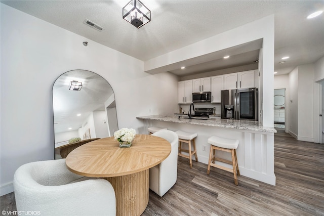 8601 Westown Pkwy Unit 21207, West Des Moines, IA 50266 - dining room featuring dark wood finished floors, recessed lighting, baseboards, and arched walkways