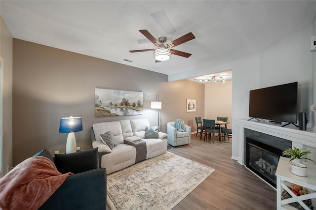 1117 S 52nd St Unit 1707, West Des Moines, IA 50265 - living room with ceiling fan, wood finished floors, a chandelier, baseboards, and a glass covered fireplace