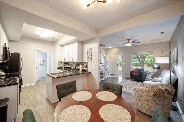 1117 S 52nd St Unit 1707, West Des Moines, IA 50265 - dining room featuring stairs, light wood finished floors, baseboards, and a ceiling fan