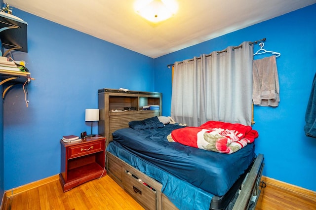 7409 Palm Dr, Urbandale, IA 50322 - bedroom featuring baseboards and wood finished floors