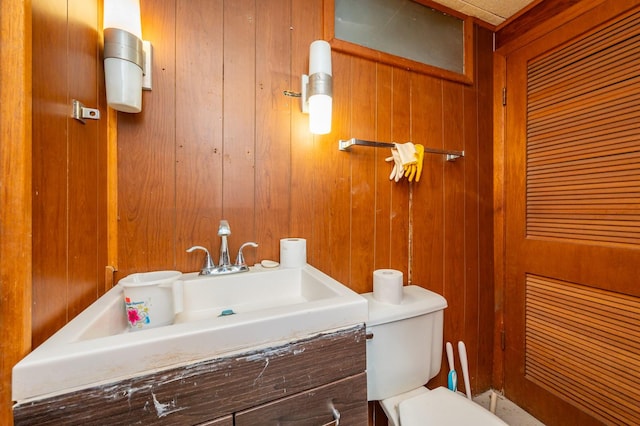 7409 Palm Dr, Urbandale, IA 50322 - bathroom with wood walls, toilet, and vanity