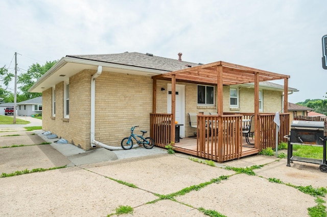 7409 Palm Dr, Urbandale, IA 50322 - back of property featuring brick siding, a deck, and roof with shingles