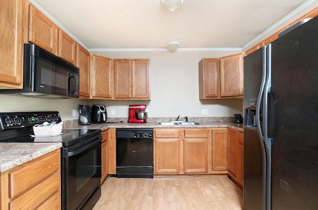 3811 SW 3rd St, Des Moines, IA 50315 - kitchen featuring black appliances, a sink, light wood finished floors, and light countertops