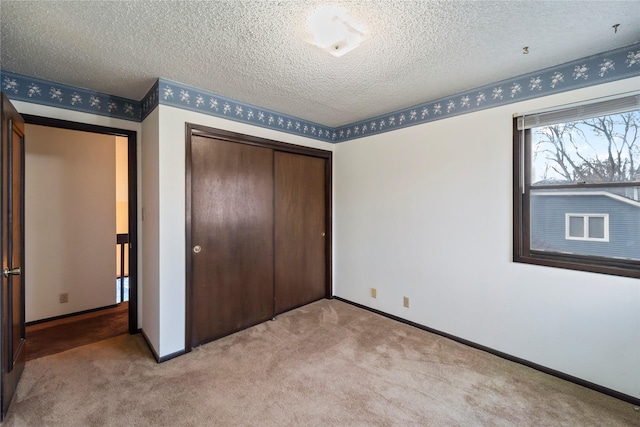 1495 Rio Valley Dr, Clive, IA 50325 - unfurnished bedroom with a closet, carpet floors, baseboards, and a textured ceiling