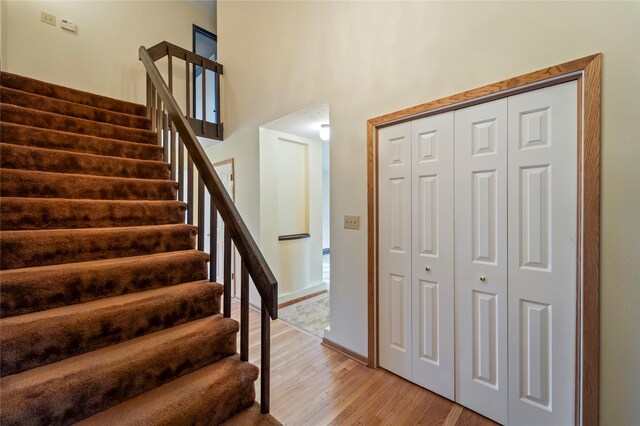1495 Rio Valley Dr, Clive, IA 50325 - stairway with wood finished floors, a towering ceiling, and baseboards