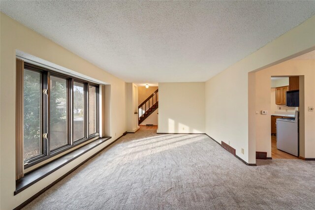 1495 Rio Valley Dr, Clive, IA 50325 - empty room featuring light colored carpet, stairs, a textured ceiling, and baseboards