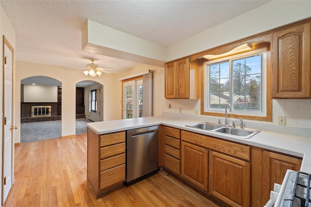1495 Rio Valley Dr, Clive, IA 50325 - kitchen featuring dishwasher, a sink, a peninsula, light wood-style flooring, and light countertops