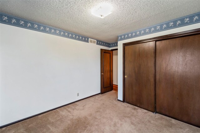 1495 Rio Valley Dr, Clive, IA 50325 - unfurnished bedroom featuring light carpet, a closet, baseboards, and a textured ceiling