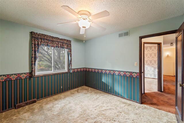 1495 Rio Valley Dr, Clive, IA 50325 - unfurnished room with carpet flooring, a ceiling fan, wainscoting, and a textured ceiling