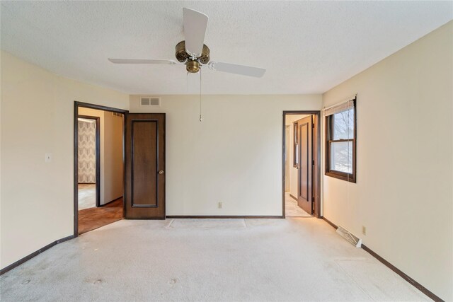 1495 Rio Valley Dr, Clive, IA 50325 - spare room with light carpet, baseboards, ceiling fan, and a textured ceiling