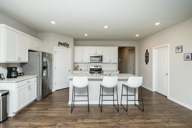 6828 NW 106th St, Johnston, IA 50131 - kitchen with appliances with stainless steel finishes, backsplash, a breakfast bar area, light countertops, and recessed lighting