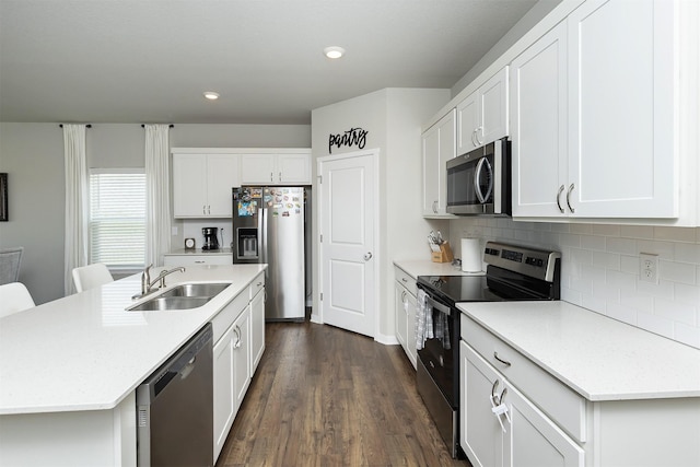 6828 NW 106th St, Johnston, IA 50131 - kitchen with appliances with stainless steel finishes, a sink, decorative backsplash, dark wood finished floors, and white cabinetry