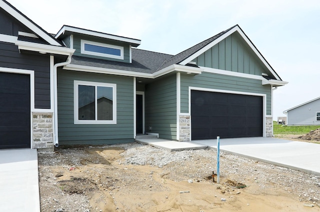 2412 NE 6th St, Grimes, IA 50111 - view of front of home with stone siding, an attached garage, and board and batten siding