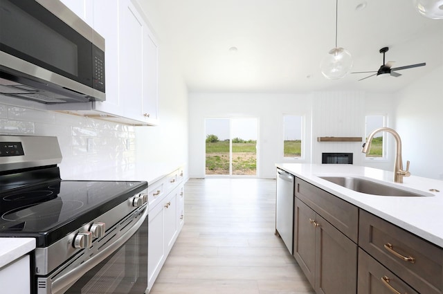 2412 NE 6th St, Grimes, IA 50111 - kitchen with appliances with stainless steel finishes, a sink, light countertops, and backsplash