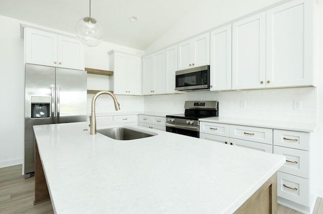 2412 NE 6th St, Grimes, IA 50111 - kitchen featuring stainless steel appliances, a sink, an island with sink, backsplash, and light wood finished floors