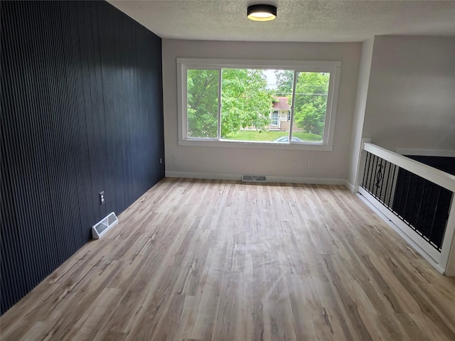 108 E Philip St, Des Moines, IA 50315 - spare room featuring wood finished floors, a textured ceiling, and baseboards