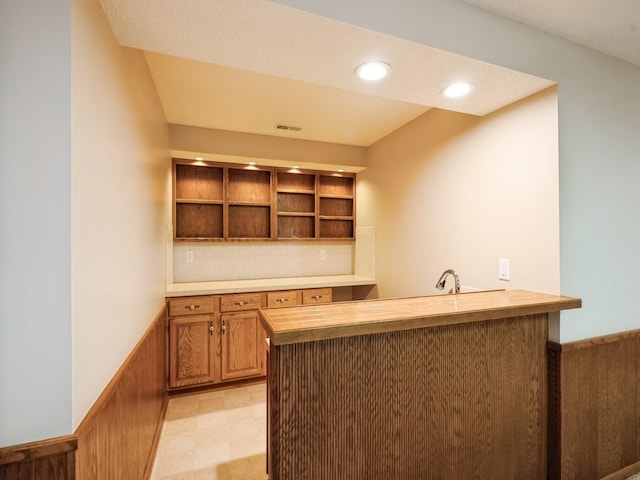 10823 Elmcrest Dr, Clive, IA 50325 - kitchen with a peninsula, butcher block counters, open shelves, brown cabinets, and recessed lighting