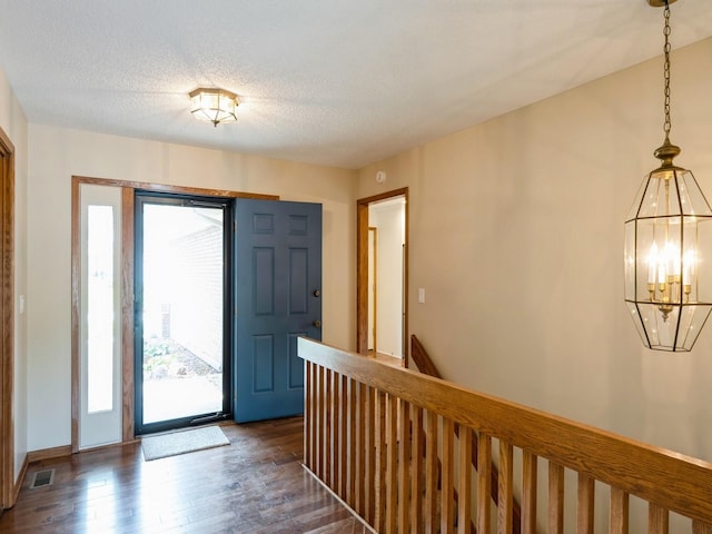 10823 Elmcrest Dr, Clive, IA 50325 - foyer entrance featuring dark wood-style flooring, a chandelier, and a textured ceiling