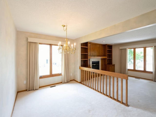 10823 Elmcrest Dr, Clive, IA 50325 - unfurnished room featuring carpet flooring, a textured ceiling, baseboards, a chandelier, and a fireplace