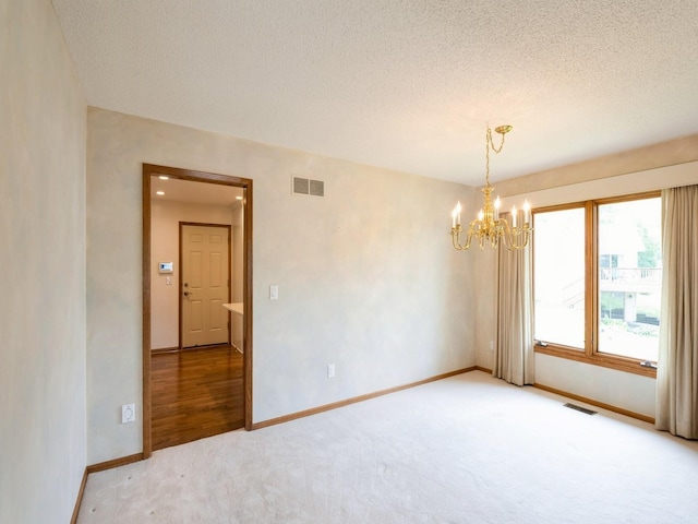 10823 Elmcrest Dr, Clive, IA 50325 - spare room featuring carpet flooring, a chandelier, baseboards, and a textured ceiling