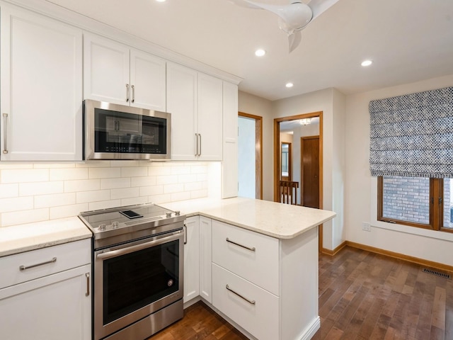 10823 Elmcrest Dr, Clive, IA 50325 - kitchen featuring stainless steel appliances, a peninsula, decorative backsplash, dark wood-type flooring, and white cabinets