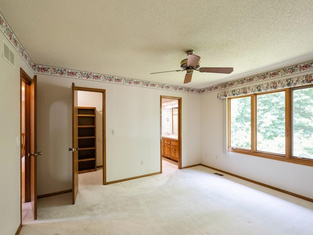 10823 Elmcrest Dr, Clive, IA 50325 - unfurnished bedroom with a textured ceiling, a spacious closet, baseboards, a closet, and light carpet