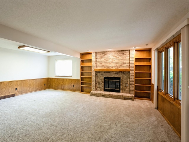 10823 Elmcrest Dr, Clive, IA 50325 - unfurnished living room with wooden walls, built in shelves, carpet, wainscoting, and a fireplace