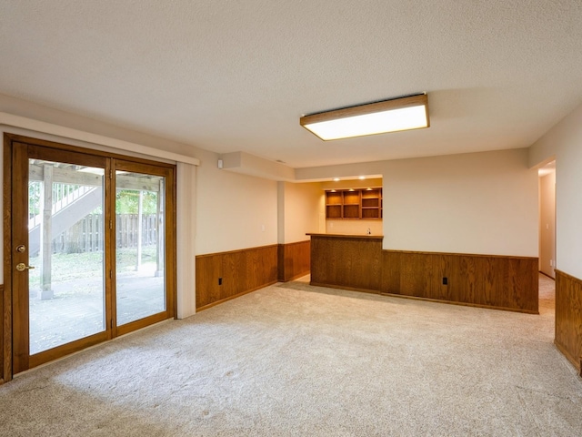 10823 Elmcrest Dr, Clive, IA 50325 - spare room with wood walls, wainscoting, carpet, and a textured ceiling