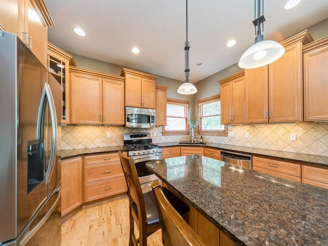 15903 Winston Ave, Urbandale, IA 50323 - kitchen with stainless steel appliances, light wood-type flooring, a breakfast bar, backsplash, and recessed lighting