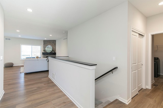 6744 NE 12th Ct, Des Moines, IA 50313 - hallway featuring an upstairs landing, light wood-type flooring, baseboards, recessed lighting, and washer / dryer