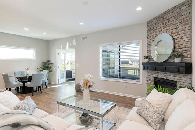 6744 NE 12th Ct, Des Moines, IA 50313 - living room featuring light wood-style flooring, recessed lighting, a fireplace, and baseboards