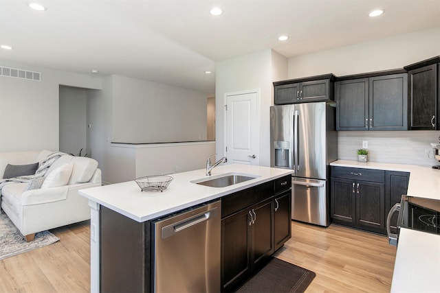 6744 NE 12th Ct, Des Moines, IA 50313 - kitchen featuring appliances with stainless steel finishes, a sink, light wood-style floors, light countertops, and recessed lighting