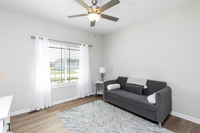 6744 NE 12th Ct, Des Moines, IA 50313 - living area featuring wood finished floors, ceiling fan, and baseboards