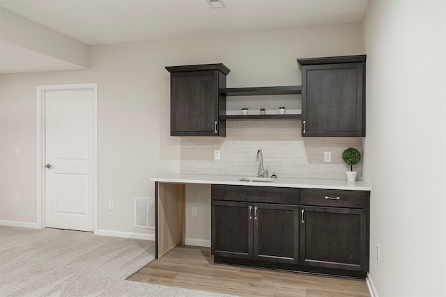 6744 NE 12th Ct, Des Moines, IA 50313 - bar area featuring tasteful backsplash, a sink, and baseboards