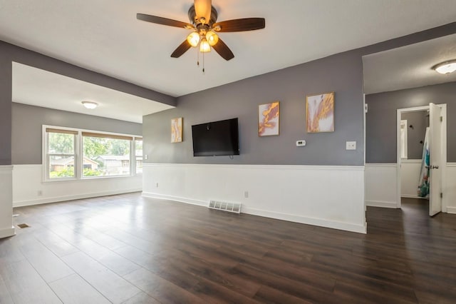 600 SE 2nd St, Grimes, IA 50111 - unfurnished living room featuring a wainscoted wall, dark wood-style floors, and ceiling fan