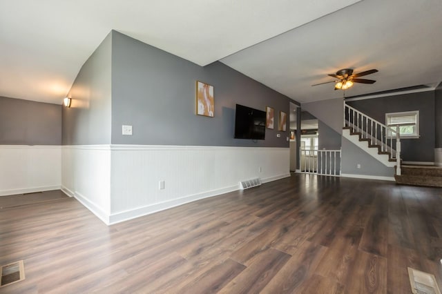 600 SE 2nd St, Grimes, IA 50111 - unfurnished living room with stairway, a wainscoted wall, wood finished floors, ceiling fan, and baseboards