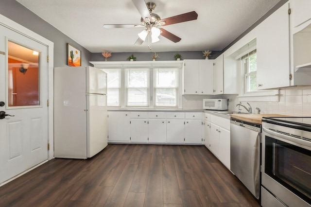 600 SE 2nd St, Grimes, IA 50111 - kitchen with appliances with stainless steel finishes, a sink, white cabinets, and backsplash