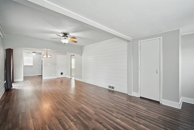 806 8th St, West Des Moines, IA 50265 - unfurnished living room with ceiling fan, arched walkways, dark wood-style flooring, and wood walls
