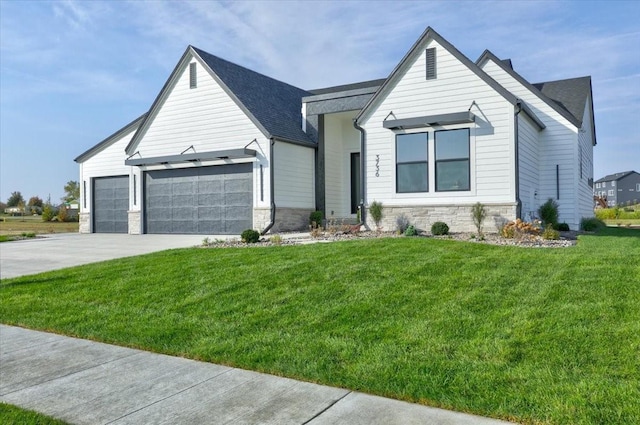 3736 NW 183rd St, Clive, IA 50325 - view of front of house featuring stone siding, a garage, concrete driveway, a front lawn, and roof with shingles