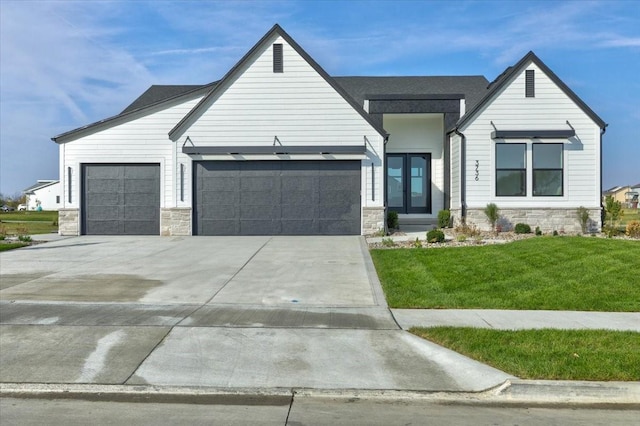 3736 NW 183rd St, Clive, IA 50325 - modern inspired farmhouse featuring stone siding, an attached garage, a front lawn, concrete driveway, and french doors