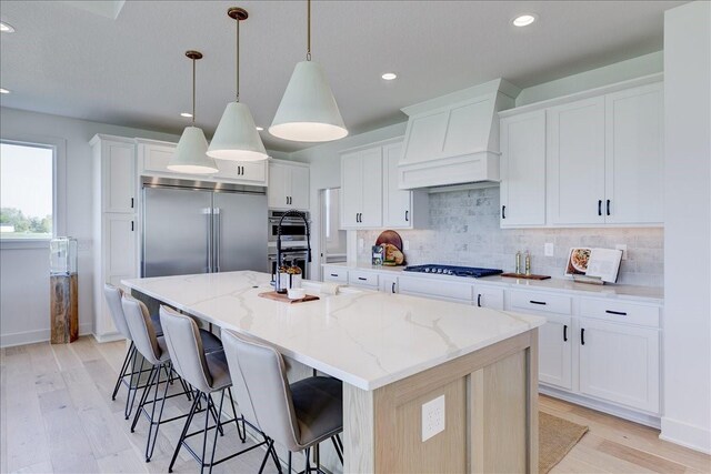 3736 NW 183rd St, Clive, IA 50325 - kitchen with stainless steel appliances, light wood-type flooring, tasteful backsplash, recessed lighting, and a spacious island