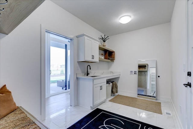 3736 NW 183rd St, Clive, IA 50325 - laundry room featuring light marble finish flooring, baseboards, and cabinet space