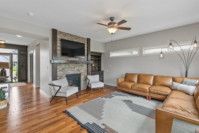 460 NE Bowman Dr, Waukee, IA 50263 - living room with baseboards, light wood-style flooring, a ceiling fan, and a fireplace