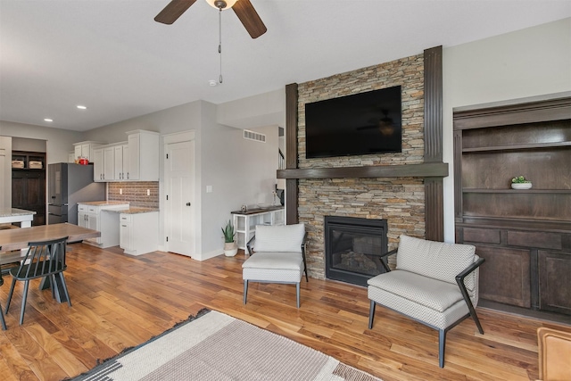 460 NE Bowman Dr, Waukee, IA 50263 - living room with ceiling fan, a fireplace, light wood-type flooring, baseboards, and recessed lighting