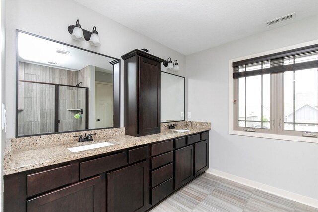 460 NE Bowman Dr, Waukee, IA 50263 - full bathroom featuring a stall shower, double vanity, and baseboards