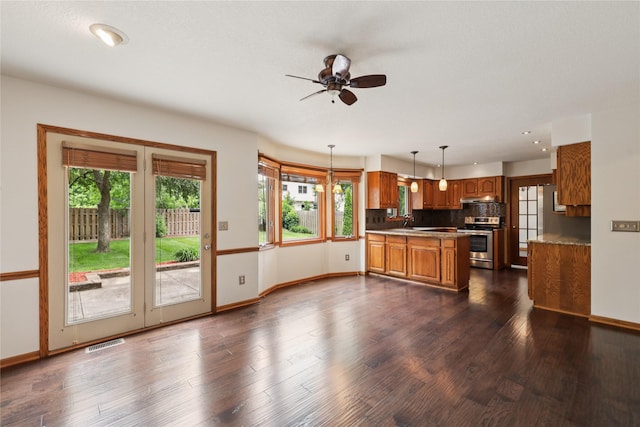 313 29th St, West Des Moines, IA 50265 - kitchen with stainless steel stove, brown cabinetry, a sink, baseboards, and recessed lighting