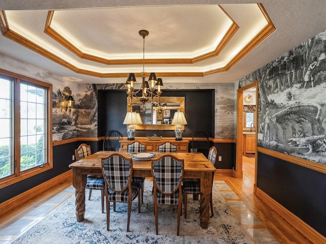 11576 NW Timberbrooke Ln, Grimes, IA 50111 - dining area with wallpapered walls, a tray ceiling, a chandelier, crown molding, and wood finished floors