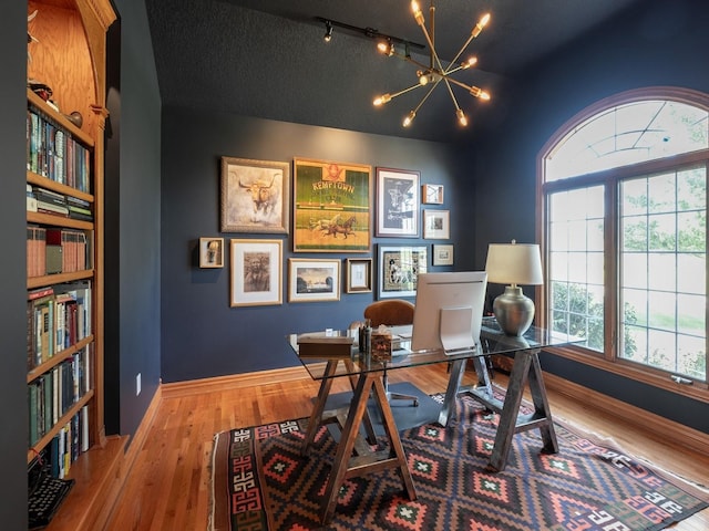 11576 NW Timberbrooke Ln, Grimes, IA 50111 - office space with wood finished floors, a chandelier, a textured ceiling, and baseboards